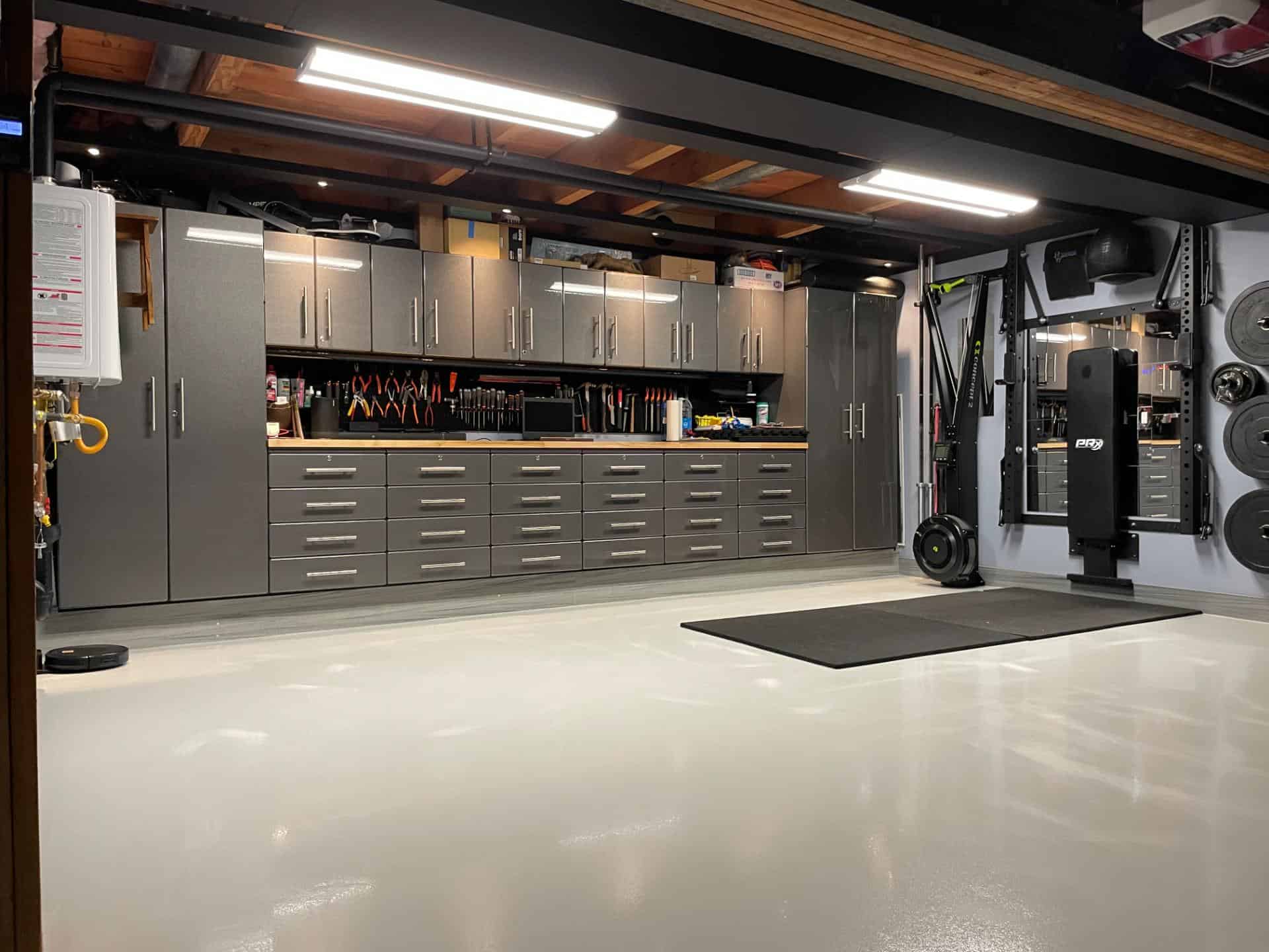 a nice epoxy garage floor with a weight room and a profesional looking shop with metal cabinets.